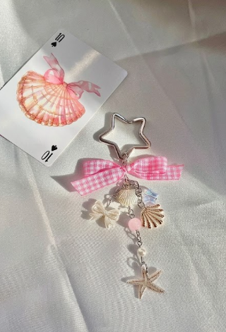 Yıldız halkalı, pembe fiyonklu ve deniz temalı tüm charmların olduğu o süs.